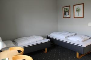 two beds sitting next to each other in a room at Danhostel Herning in Herning