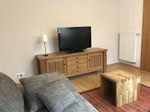 uma sala de estar com televisão num armário de madeira em Ferienwohnung im sonnigen Kaiserstuhl em Endingen
