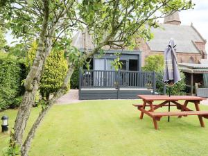 a picnic table and an umbrella in a yard at Cabin at the Tavern in Blairgowrie