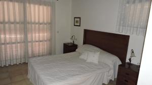 sypialnia z łóżkiem z białą pościelą i oknami w obiekcie HL 017 ·HL 017 3 bedroom 2 bathroom, villa high standard w mieście Fuente Alamo