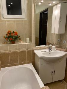 a bathroom with a tub and a sink and a mirror at Budapest Central Andrassy Apartment in Budapest