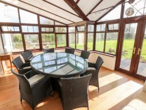 a dining room with a glass table and chairs at Mountain Farm in Haverfordwest