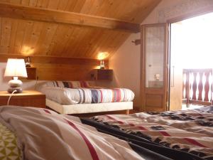 a bedroom with two beds and a wooden ceiling at Chalet Analma in Planay
