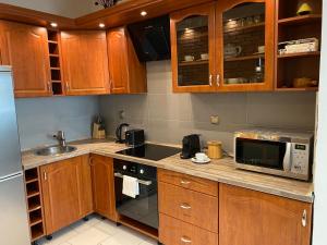 a kitchen with wooden cabinets and a sink and a microwave at Budapest Central Andrassy Apartment in Budapest