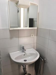 uma casa de banho com um lavatório branco e um espelho. em Apartment in EG Schaupenstiel em Northeim
