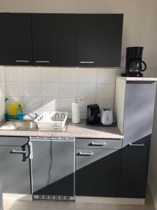 uma cozinha com armários pretos e uma bancada em Apartment in EG Schaupenstiel em Northeim