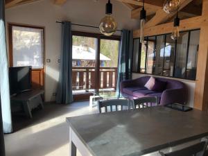 モルジヌにあるChalet Croq'Neigeのリビングルーム(紫色のソファ、テレビ付)