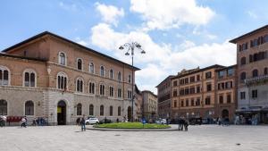 uma praça da cidade com edifícios e pessoas a passear em Domus Nannini SPA - L' Arco di Matteotti em Siena