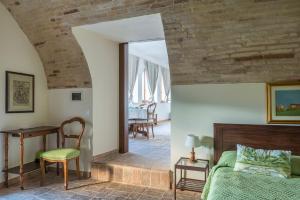 a bedroom with a bed and a table and a desk at Torre della Loggia - Dimora Storica - Ortona in Ortona