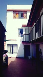 Hostel Viajeros Arequipa في أريكيبا: مبنى أبيض مع شرفة على جانبه