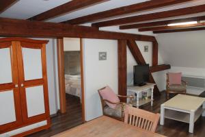 a living room with a table and a tv at Grand Gite Angelique avec Jardin - Centre Ribeauvillé in Ribeauvillé