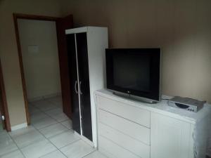 un televisor sentado en la parte superior de un tocador en una habitación en Chácara Rio Cachoeira en Antonina