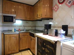 - une cuisine avec des placards en bois et un comptoir dans l'établissement Casa el Sotillo, à Villoslada de Cameros