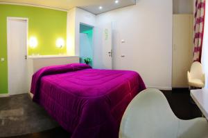 1 dormitorio con 1 cama de color púrpura y 1 silla en The Fresh Glamour Accommodation, en Nápoles