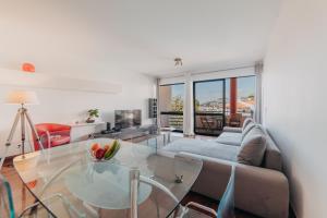 a living room with a glass table and a couch at Funchal Lounge Apartment by Amazing Madeira in Funchal