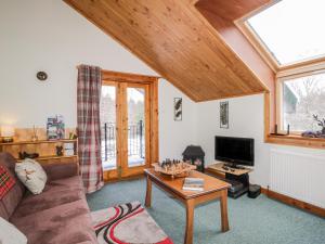 a living room with a couch and a table at Torbreck Chalet in Kingussie