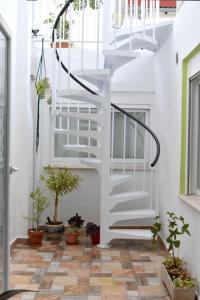 a hallway with a white staircase and potted plants at Casa Cabanyal in Valencia