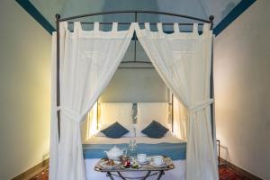 Una cama con dosel y una mesa delante. en B&B Sant'Agostino, en Palermo