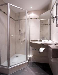 a bathroom with a shower and a sink at Hotel Restaurant Erber in Ismaning