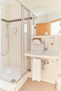 uma casa de banho com um lavatório e um chuveiro em Hotel Restaurant Erber em Ismaning
