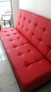 un sofá rojo sentado en una habitación en Reserva del Peñon, en Girardot