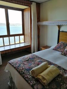 a bedroom with two beds and a large window at Laguneclub - Su casa de campo in Frutillar