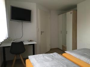 a bedroom with a desk and a television on the wall at Apartment Staudacker in Drage