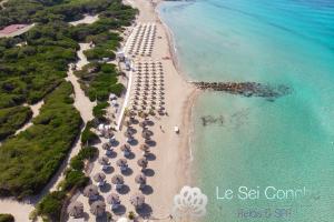 una vista aerea su una spiaggia con ombrelloni e sull'oceano di Le Sei Conche Relais & SPA a Gemini