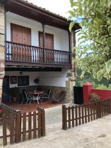 una casa con balcone, tavolo e sedie di CASA RURAL DOSAL a Ruiseñada