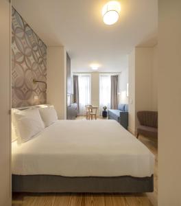 a bedroom with a large bed and a large window at Lisbon Serviced Apartments - Santos in Lisbon