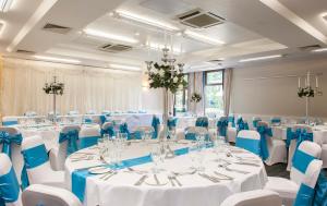 Salón de baile con mesas y sillas y adornos azules y blancos en Holiday Inn Haydock, an IHG Hotel en Haydock