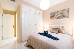 1 dormitorio con 1 cama con 2 toallas azules en Céntrico II Donkey Parking incluido, en Sevilla