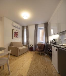 uma pequena sala de estar com um sofá e uma cozinha em Lisbon Serviced Apartments - Santos em Lisboa