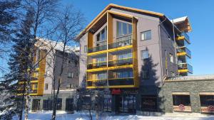 um edifício de apartamentos com amarelo e cinza em Levin Kunkku C9 em Levi