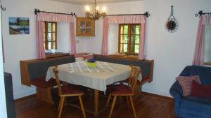a dining room with a table and two windows at Ferienhaus Lenzau in Strohmarkt