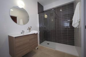 La salle de bains est pourvue d'un lavabo et d'une douche avec un miroir. dans l'établissement Apartaments Sa Calm Sant Miquel de les Formigues, à Sant Hilari Sacalm