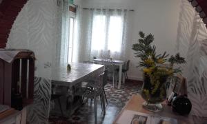 a dining room with a table and a vase of flowers at Hotel Clair Logis in Argelès-sur-Mer