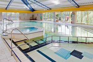 a swimming pool with a hot tub in a building at Holiday Inn Runcorn M56 Junction 12, an IHG Hotel in Runcorn