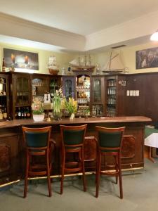 a bar in a room with chairs around it at Bluhm's Hotel & Restaurant am Markt in Kyritz