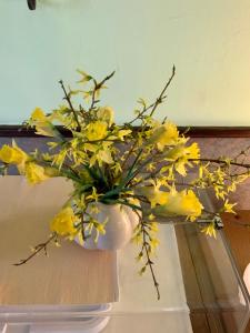 Bluhm's Hotel & Restaurant am Markt في كيريتز: مزهرية مليئة بالورود الصفراء على طاولة