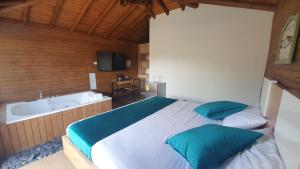 1 dormitorio con 1 cama grande y bañera en Sotavento Cabañas en Guatapé