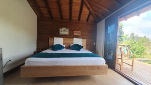 una camera da letto con un letto e una grande finestra di Sotavento Cabañas a Guatapé