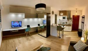 a kitchen and a living room with a table at La charmeraie in Compiègne