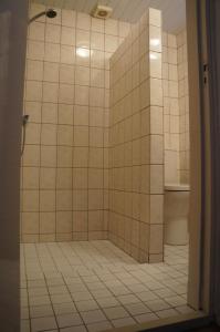 een badkamer met een douche met witte tegels bij Wijngaardstraat 7a Domburg in Domburg +11 foto's