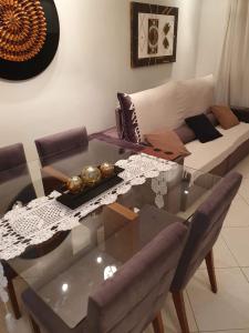 a living room with a glass table and a couch at Apartamento dois quartos perto da praia em Jardim Camburi in Vitória