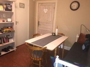 
a kitchen with a table and chairs and a clock at Brunius Bed and Breakfast in Lund
