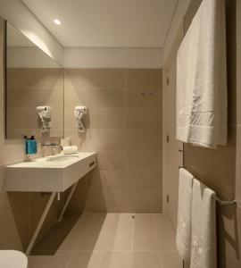 a bathroom with a sink, toilet and mirror at Lisbon Serviced Apartments - Santos in Lisbon