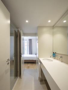 a bathroom with a large mirror and a sink at Lisbon Serviced Apartments - Santos in Lisbon