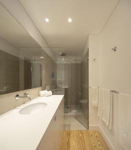 a bathroom with a sink, mirror, and bathtub at Lisbon Serviced Apartments - Santos in Lisbon
