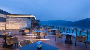 淳安的住宿－杭州千島湖皇冠假日酒店，一间在甲板上配有桌椅的餐厅